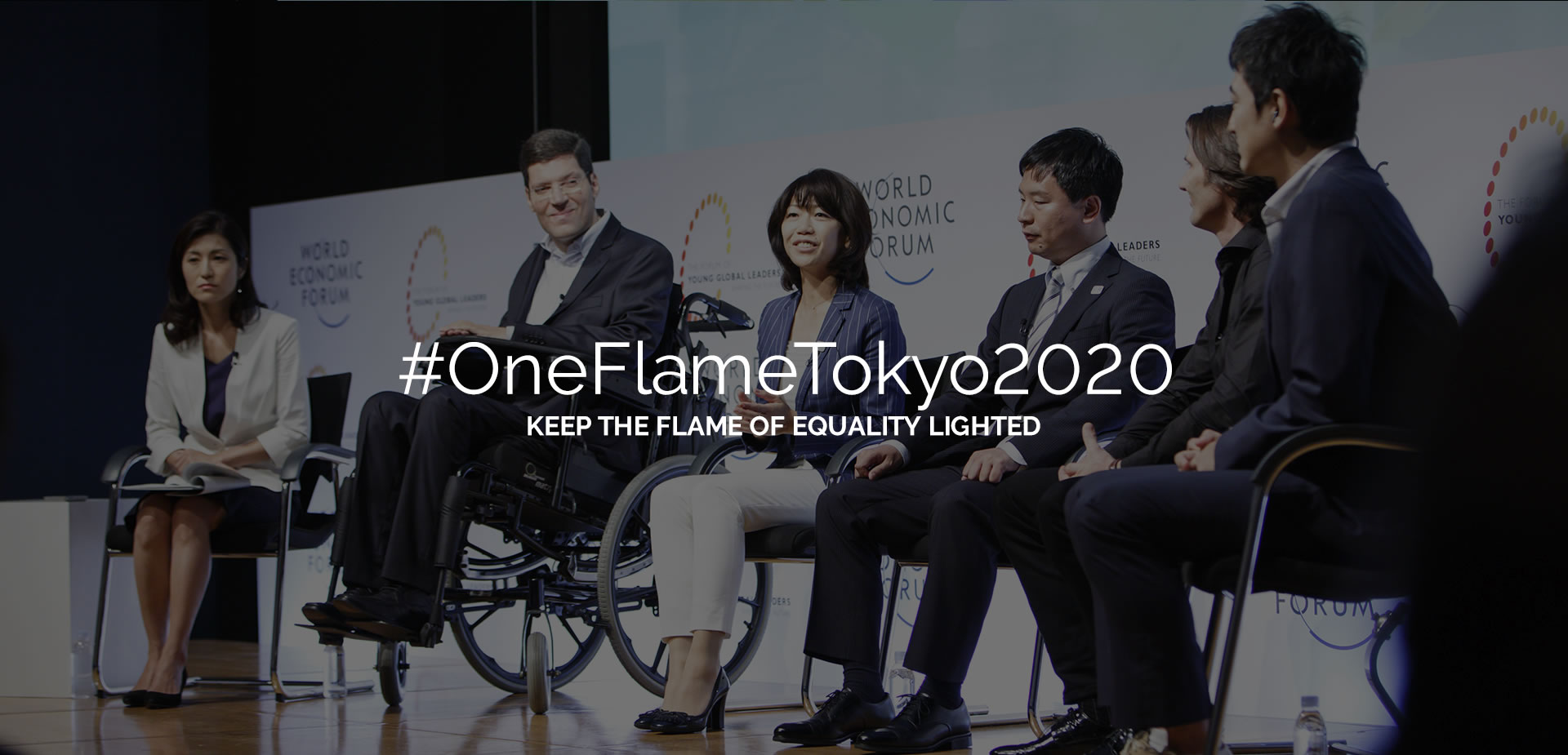 #OneFlameTokyo2020 Mantenha a chama da igualdade acesa. Rodrigo Hübner Mendes entre cinco pessoas, todos sentados no palco do World Economic Forum em Tóquio.